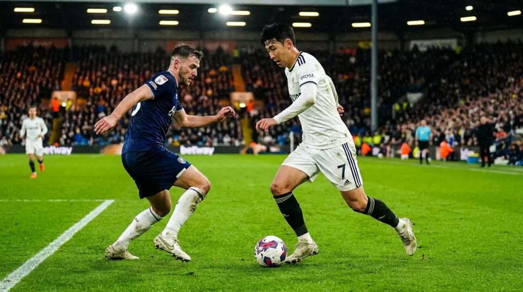 Campo de fútbol visto desde la grada con jugadores en plena jugada durante un partido nocturno